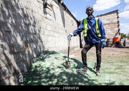 210518 -- LUSAKA, May 18, 2021 -- Charles Tembo stands over recycled materials for making building blocks in Lusaka, Zambia, on May 13, 2021. Charles Tembo, a 37-year-old resident of Lusaka, the Zambian capital, has come up with a way of turning used plastic products like bottles into a venture of making building blocks instead of using quarry. Photo by /Xinhua TO GO WITH Feature: Zambian entrepreneur determined to process used plastic products ZAMBIA-LUSAKA-RECYCLED MATERIALS-BLOCK MAKING MartinxMbangweta PUBLICATIONxNOTxINxCHN Stock Photo