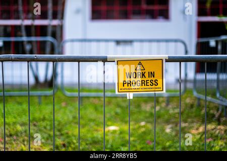 Work in progress sign on iron fence Stock Photo