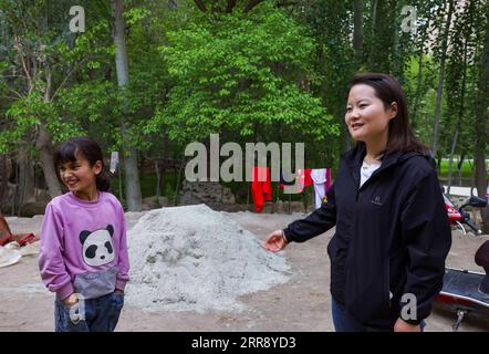 210520 -- AKTO, May 20, 2021 -- Chen Fangying chats with a student at Alimalik Village of Akto County, northwest China s Xinjiang Uygur Autonomous Region, May 12, 2021. Chen Fangying, a 24-year-old village teacher, is from southwest China s Guizhou Province. When she graduated from college two years ago, she chose to become a teacher in Xinjiang. The primary school where Chen teaches is located in the Kunlun Mountains, more than 1,800 kilometers away from Xinjiang s capital city Urumqi. For me, this is the life I should live in my twenties, said Chen. Chen Fangying has more than ten classes ev Stock Photo