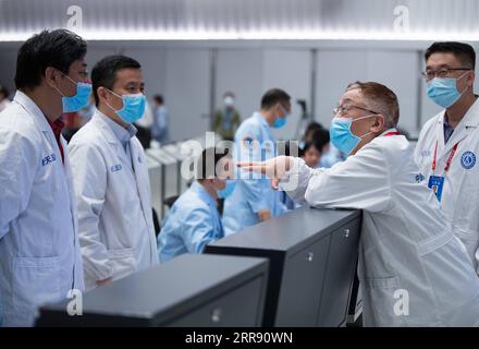 210522 -- BEIJING, May 22, 2021 -- Ye Peijian 2nd R, academician of the Chinese Academy of Sciences CAS and senior spacecraft expert, talks with space experts after China s first Mars rover, Zhurong, driving down from its landing platform to the Martian surface, at the Beijing Aerospace Control Center in Beijing, capital of China, May 22, 2021. China s first Mars rover, Zhurong, drove down from its landing platform to the Martian surface Saturday, leaving the country s first footprints on the red planet. Zhurong s first successful drive made China the second country after the United States to Stock Photo