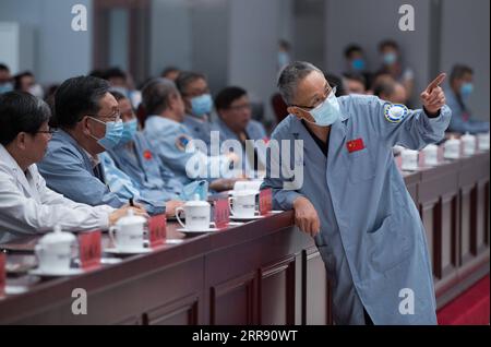 210522 -- BEIJING, May 22, 2021 -- Zhang Rongqiao R, chief designer of China s first Mars exploration mission, talks with Wu Weiren 2nd L, chief designer of China s lunar exploration project after China s first Mars rover, Zhurong, driving down from its landing platform to the Martian surface, at the Beijing Aerospace Control Center in Beijing, capital of China, May 22, 2021. China s first Mars rover, Zhurong, drove down from its landing platform to the Martian surface Saturday, leaving the country s first footprints on the red planet. Zhurong s first successful drive made China the second cou Stock Photo