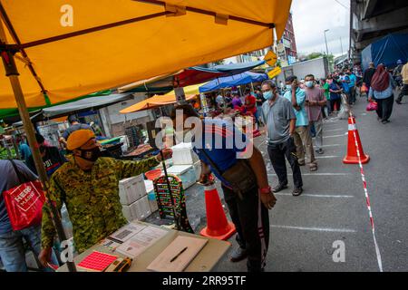 210529 -- KUALA LUMPUR, May 29, 2021 -- People wearing face masks line up to enter a market before a lockdown in Kuala Lumpur, Malaysia, May 29, 2021. Malaysia reported jumps in the highest daily record of new COVID-19 cases and deaths on Saturday, after the government announced a total lockdown to contain the outbreak. A new daily high of 9,020 infections were reported, an increase from the previous high of 8,290 cases just recorded a day ago, bringing the national total to 558,534, according to the health ministry. A recent spike of COVID-19 cases in Malaysia has forced the government to ann Stock Photo