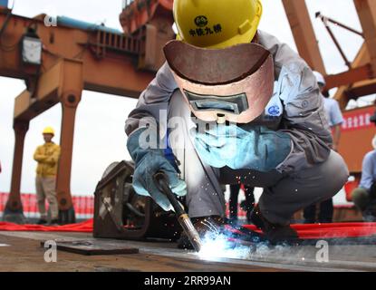 210603 -- WUHAN, June 3, 2021 -- A worker welds the last part of the steel girder at the closure segment of Bianyuzhou Yangtze River Bridge on the border of central China s Hubei Province and east China s Jiangxi Province, June 3, 2021. Connecting Huangmei County of central China s Hubei Province and Jiujiang City of east China s Jiangxi Province, the bridge is part of Anqing-Jiujiang Railway. The railway has a designed speed of 350 kilometers per hour for the two high speed lines and 200 kilometers per hour for the other two reserved passenger and freight lines.  CHINA-ANQING-JIUJIANG-RAILWAY Stock Photo