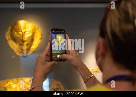 210617 -- ATHENS, June 17, 2021 -- A visiter takes pictures of exhibits at the National Archaeological Museum in Athens, Greece, June 7, 2021. The imposing golden mask of Agamemnon welcomes visitors at the National Archaeological Museum here, standing out among other finds from the royal cemetery of the ancient city of Mycenae on the Peloponnese peninsula dating back to the 16th century BC. TO GO WITH Interview: Ancient Greek golden death-masks of Mycenae still engulfed in mystery, says archaeologist  GREECE-ATHENS-GOLD MASKS-NATIONAL ARCHAEOLOGICAL MUSEUM MariosxLolos PUBLICATIONxNOTxINxCHN Stock Photo