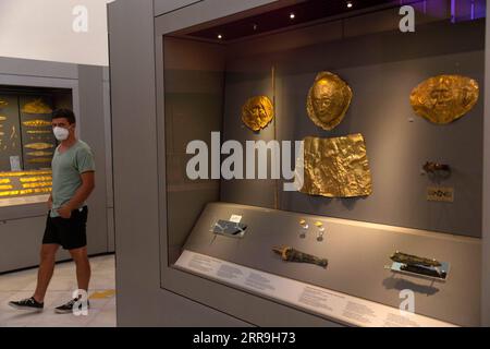 210617 -- ATHENS, June 17, 2021 -- A visiter views exhibits at the National Archaeological Museum in Athens, Greece, June 7, 2021. The imposing golden mask of Agamemnon welcomes visitors at the National Archaeological Museum here, standing out among other finds from the royal cemetery of the ancient city of Mycenae on the Peloponnese peninsula dating back to the 16th century BC. TO GO WITH Interview: Ancient Greek golden death-masks of Mycenae still engulfed in mystery, says archaeologist  GREECE-ATHENS-GOLD MASKS-NATIONAL ARCHAEOLOGICAL MUSEUM MariosxLolos PUBLICATIONxNOTxINxCHN Stock Photo