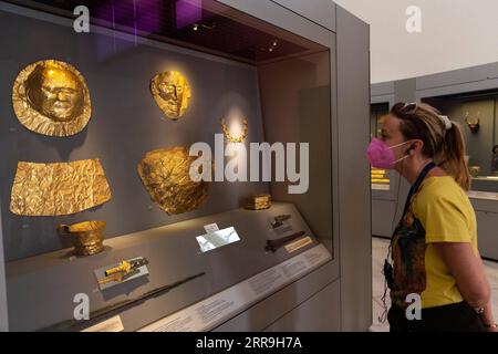 210617 -- ATHENS, June 17, 2021 -- A visiter views exhibits at the National Archaeological Museum in Athens, Greece, June 7, 2021. The imposing golden mask of Agamemnon welcomes visitors at the National Archaeological Museum here, standing out among other finds from the royal cemetery of the ancient city of Mycenae on the Peloponnese peninsula dating back to the 16th century BC. TO GO WITH Interview: Ancient Greek golden death-masks of Mycenae still engulfed in mystery, says archaeologist  GREECE-ATHENS-GOLD MASKS-NATIONAL ARCHAEOLOGICAL MUSEUM MariosxLolos PUBLICATIONxNOTxINxCHN Stock Photo