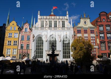 The Old Town of Gdańsk in Poland. Artus Court (Dwór Artusa), Neptune Fountain and historic tenement houses with gables at Long Market (Długi Targ). Stock Photo