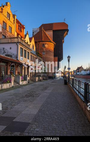 City of Gdańsk in Poland, sunrise in the Old Town with the Crane, historic apartment houses on Long Embankment (Długie Pobrzeże) street at Motława Riv Stock Photo