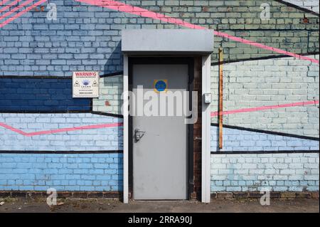 Old Brick Wall & Door Painted with Colourful Abstract Geometric Patterns in the Baltic Triangle Area of Liverpool England UK Stock Photo