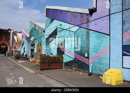 Old Brick Wall Painted with Colourful Abstract Geometric Patterns in the Baltic Triangle Area of Liverpool England UK Stock Photo