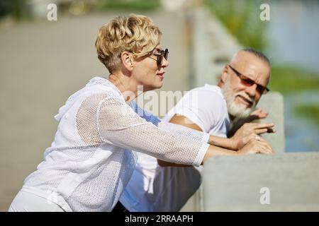 Mature stylish people doing fitness outdoors, training, running, stretching, Taking care after body Stock Photo