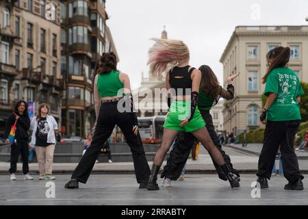 Brussels, Belgium - June 27 2023: Back view of street dancer girl group performing dance and tourists watch them Stock Photo