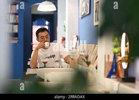 210726 -- QUANZHOU, July 26, 2021 -- A man enjoys coffee at an exhibition center on coffee culture in Licheng District of Quanzhou, southeast China s Fujian Province, July 8, 2021. Quanzhou is located on the southeast coast of China s Fujian Province. In the Song 960-1279 and Yuan 1271-1368 dynasties, Quanzhou was known as the largest port in the East . With numerous merchant ships from the East and the West coming and going day and night, the prosperity of the city was vividly recorded in many historical materials and The Travels of Marco Polo , which recounts the journey of the Italian explo Stock Photo
