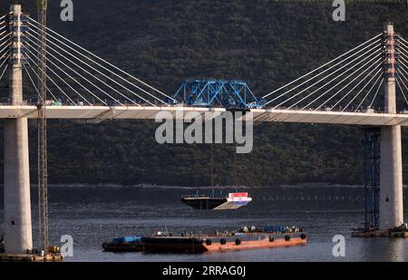 210729 -- KOMARNA, July 29, 2021 -- Photo taken on July 28, 2021 shows the final piece of steel box girder being lifted at Mali Ston Bay near Komarna of southern Croatia. The final piece of steel box girder for the Peljesac Bridge in southern Croatia was lifted and welded with the main structure on late Wednesday night. The 2.4-km cable-stayed bridge over the Mali Ston Bay of the Adriatic Sea connects Croatian mainland and the Peljesac Peninsula of its southernmost Dubrovnik-Neretva County, bypassing a short strip of Bosnian and Herzegovina s territory. /Pixsell via Xinhua CROATIA-KOMARNA-PELJ Stock Photo