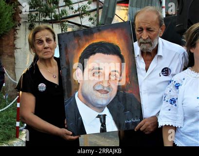 210804 -- BEIRUT, Aug. 4, 2021 -- Family members of a firefighter martyr are offered his portrait at an art exhibition commemorating the martyrdom of 10 firefighters upon the first anniversary of the Beirut port blast in Beirut, Lebanon, Aug. 3, 2021.  LEBANON-BEIRUT-PORT-EXPLOSION-ANNIVERSARY-COMMEMORATION LiuxZongya PUBLICATIONxNOTxINxCHN Stock Photo