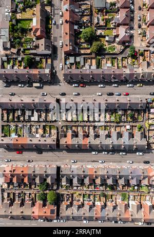 An aerial view directly above the rooftops of rows of back to back terraced houses with alleyways and gardens in a working class area of a Northern to Stock Photo