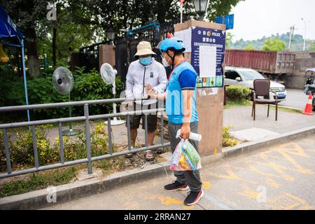 210809 -- ZHANGJIAJIE, Aug. 9, 2021 -- Delivery man Yan Yingzhao shows his health-tracking code while entering a community in Yongding District of Zhangjiajie, central China s Hunan Province, Aug. 9, 2021. Since last Tuesday, all the people in the central Chinese city of Zhangjiajie, including residents and tourists, are not allowed to leave the city as part of efforts to curb the latest resurgence of COVID-19. Local authorities have prioritized delivery services to ensure the supply of necessities. Couriers like 22-year-old Yan Yingzhao are working day and night to deliver food items and medi Stock Photo