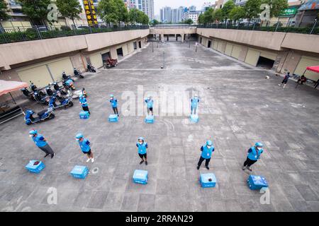 210809 -- ZHANGJIAJIE, Aug. 9, 2021 -- Delivery couriers have a morning meeting in Yongding District of Zhangjiajie, central China s Hunan Province, Aug. 9, 2021. Since last Tuesday, all the people in the central Chinese city of Zhangjiajie, including residents and tourists, are not allowed to leave the city as part of efforts to curb the latest resurgence of COVID-19. Local authorities have prioritized delivery services to ensure the supply of necessities. Couriers like 22-year-old Yan Yingzhao are working day and night to deliver food items and medical supplies to the doorsteps of residents Stock Photo