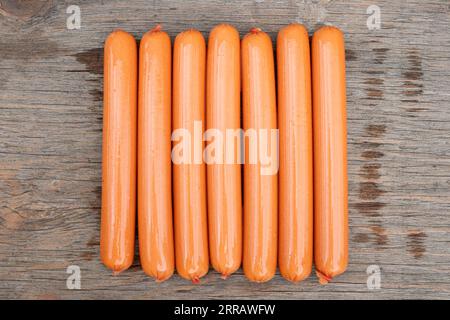 Raw pork classic sausages on stone Board with rosemary and spices. Black background. Top view. dog sausages Stock Photo