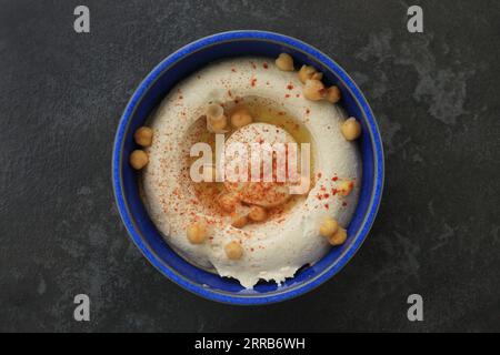 A Lebanese traditional plate of hummus with olive oil, chickpeas, and a chili flakes. Stock Photo