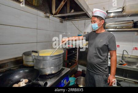 210908 -- TIANJIN, Sept. 8, 2021 -- Li Chao prepares breakfast for customers in Xiaoxinmatou Village of Baodi District in Tianjin, north China, Sept. 3, 2021. Li Chao is a post-90s born in Xiaoxinmatou Village in Baodi District. Located by the Chaobai River, the village used to witness an outflow of young people, as villagers made a living by traditional fishing and farming with low income. Like his young fellows, Li chose to be a migrant worker in the city for higher income. Waiter, chef, assembly line worker, security guard and salesman...the diligent man tried his hand at a variety of jobs Stock Photo