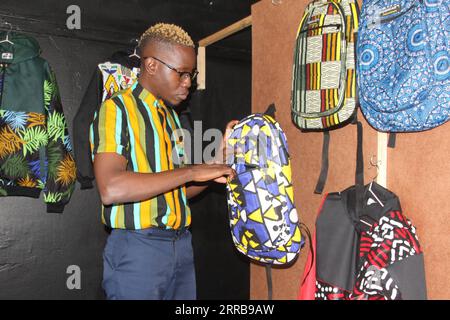 210909 -- HARARE, Sept. 9, 2021 -- Bakari Sibanda checks a backpack made from African print fabric at his shop in Harare, capital of Zimbabwe, Sept. 1, 2021. Bakari Sibanda, founder and creative director of Harare-based byBakari fashion brand, uses African print fabric to make stylish clothing that reflects the artistic expression of African culture. TO GO WITH Feature: Zimbabwean fashion entrepreneur fuses tradition with modernity in eye-catching ways  ZIMBABWE-HARARE-FASHION ENTREPRENEUR-AFRICAN PRINT FABRIC TafaraxMugwara PUBLICATIONxNOTxINxCHN Stock Photo