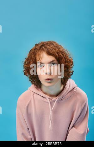 Blue haired Teenage girl in blue hoodie staying near graffiti wall with red water  bottle Stock Photo by katrinshine