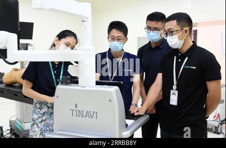 210912 -- BEIJING, Sept. 12, 2021 -- Liu Tiechang 2nd L and his colleagues of Tinavi, a Chinese tech company that specializes in the development of orthopedic surgical robots, work in a lab in Beijing, capital of China, Aug. 4, 2021. The orthopedic surgical robot could dynamically analyze the patient s anatomy as well as the spine-hip relation and carry out the individualized surgery planning exactly as planned. Beijing Haidian Hospital officially introduced orthopedic surgery robots from May 2020, and has completed more than 400 robotic surgeries by the end of August 2021.  CHINA-BEIJING-ORTH Stock Photo