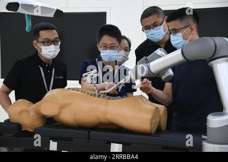210912 -- BEIJING, Sept. 12, 2021 -- Liu Tiechang 2nd L and his colleagues of Tinavi, a Chinese tech company that specializes in the development of orthopedic surgical robots, work in a lab in Beijing, capital of China, Aug. 4, 2021. The orthopedic surgical robot could dynamically analyze the patient s anatomy as well as the spine-hip relation and carry out the individualized surgery planning exactly as planned. Beijing Haidian Hospital officially introduced orthopedic surgery robots from May 2020, and has completed more than 400 robotic surgeries by the end of August 2021.  CHINA-BEIJING-ORTH Stock Photo