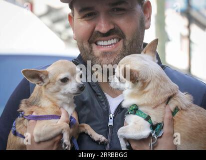 210912 -- VANCOUVER, Sept. 12, 2021 -- A man carries his dogs during the Pet-A-Palooza event in Vancouver, Canada, on Sept. 12, 2021. The annual pet event returned this year after being cancelled in 2020 due to COVID-19 pandemic, which brought more than a thousand dog owners to participate and share the joy with their pets through various activities. Photo by /Xinhua CANADA-VANCOUVER-PET-EVENT LiangxSen PUBLICATIONxNOTxINxCHN Stock Photo