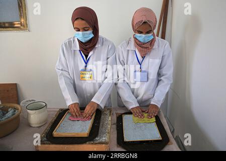 210922 -- GAZA, Sept. 22, 2021 -- Volunteers process paper waste in al-Nuseirat refugee camp in the central Gaza Strip, on Sept. 16, 2021. TO GO WITH: Feature: Gazan couple turns paper waste into eco-friendly drawing boards Photo by /Xinhua MIDEAST-GAZA-PAPER WASTE-RECYCLING RizekxAbdeljawad PUBLICATIONxNOTxINxCHN Stock Photo