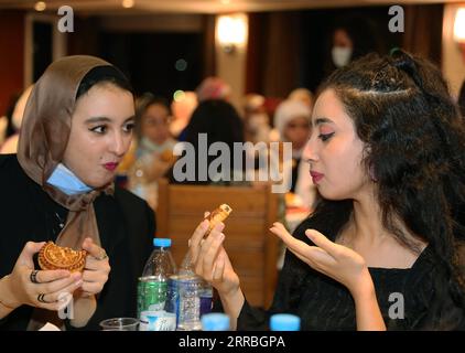 210922 -- CAIRO, Sept. 22, 2021 -- University students taste mooncakes at the Mid-Autumn cultural experience activity in Cairo, Egypt, Sept. 21, 2021. A Mid-Autumn Cultural Experience Activities organized by Chinese language club in Cairo was held on Tuesday.  EGYPT-CAIRO-CHINESE LANGUAGE CLUB-MID-AUTUMN FESTIVAL WangxDongzhen PUBLICATIONxNOTxINxCHN Stock Photo