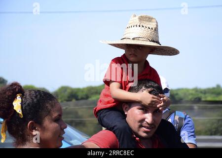 211025 -- CHIAPAS, Oct. 25, 2021 -- A migrant carries a child while taking part in a caravan bound for Mexico City, in Huehuetan, Chiapas state, in southeastern Mexico, on Oct. 24, 2021. A migrant caravan departed Saturday morning from Tapachula, Chiapas state, bound for Mexico City, where they will seek to regularize their immigration status. Photo by /Xinhua MEXICO-CHIAPAS-MIGRANTS DamianxSanchez PUBLICATIONxNOTxINxCHN Stock Photo