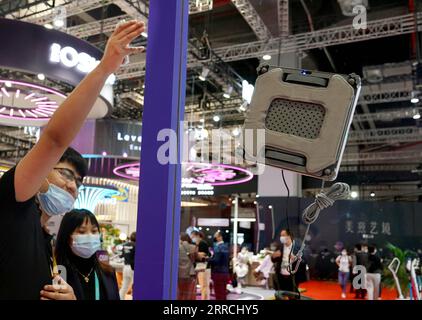 211107 -- SHANGHAI, Nov. 7, 2021 -- A staff member introduces a window cleaning robot at the Consumer Goods Exhibition Area of the 4th China International Import Expo CIIE in east China s Shanghai, Nov. 6, 2021.  CIIECHINA-SHANGHAI-CIIE-CONSUMER GOODS-EXHIBITS CN LiuxYing PUBLICATIONxNOTxINxCHN Stock Photo