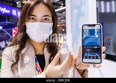 211107 -- SHANGHAI, Nov. 7, 2021 -- A staff member displays a glucose continuous monitoring system at the booth of Bayer at the Medical Equipment and Healthcare Products Exhibition Area of the 4th China International Import Expo CIIE in east China s Shanghai, Nov. 7, 2021.  CIIECHINA-SHANGHAI-CIIE-MEDICAL EQUIPMENT AND HEALTHCARE PRODUCTS EXHIBITION AREA CN ZhangxYuwei PUBLICATIONxNOTxINxCHN Stock Photo