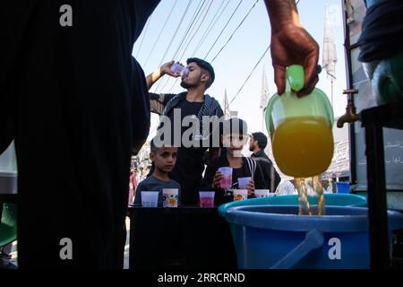 September 7, 2023, Srinagar, Jammu and Kashmir, India: A Shia Muslim distributes water to Shiite Muslim pilgrims during an Arbaeen Procession in Srinagar. Arbaeen ('Forty'' in Arabic) marks the 40th day of mourning for the martyr Imam Hussein, grandson of the Prophet Mohammed and a founding figure of Shia Islam. (Credit Image: © Adil Abbas/ZUMA Press Wire) EDITORIAL USAGE ONLY! Not for Commercial USAGE! Stock Photo