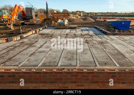 New housing estate, early morning on a December weekend. The sun’s dawning glow lighting up the scene, chasing away the night clouds from a blue sky. Stock Photo