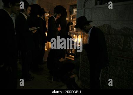211129 -- JERUSALEM, Nov. 29, 2021 -- Ultra-Orthodox Jewish men pray in front of candles during Hanukkah in Jerusalem, on Nov. 29, 2021. Photo by /Xinhua MIDEAST-JERUSALEM-HANUKKAH MuammarxAwad PUBLICATIONxNOTxINxCHN Stock Photo