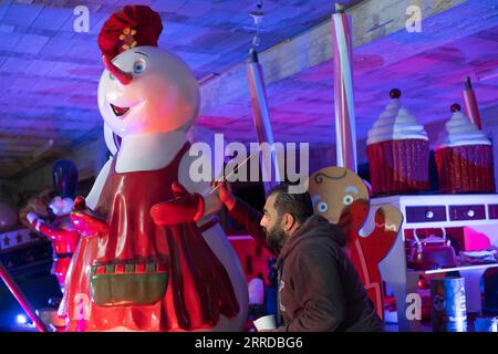 211215 -- BETHLEHEM, Dec. 15, 2021 -- A Palestinian works on Christmas figures placed on trailers, which will be used in the annual Christmas Caravan Parade, in the West Bank city of Bethlehem on Dec. 15, 2021. The annual Christmas parade will tour Bethlehem and Ramallah to bring joy to children and their families. Photo by /Xinhua MIDEAST-BETHLEHEM-CHRISTMAS-PREPARATION LuayxSababa PUBLICATIONxNOTxINxCHN Stock Photo