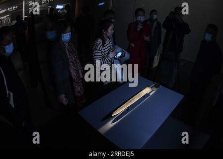 211221 -- WUHAN, Dec. 21, 2021 -- Visitors look at the Sword of Goujian, which was named after the king of the state of Yue during the Spring and Autumn Period 770-476 BC, in Hubei Provincial Museum in Wuhan, central China s Hubei Province, Dec. 20, 2021. The Hubei Provincial Museum, located in the central Chinese city of Wuhan, opened a new exhibition hall on Monday, with its most famous exhibits moved to the new location. The museum is one of the best known in China, with more than 240,000 items in the collection and nearly 1,000 top state-level historic and cultural relics, according to the Stock Photo