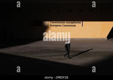 211221 -- BRUSSELS, Dec. 21, 2021 -- A man walks past the European Commission building in Brussels, Belgium, on Dec. 21, 2021. Belgium is in the midst of a new wave of COVID-19 pandemic due to the Omicron variant, which represented 20 percent of all positive test results across the country reported Monday morning, according to microbiologist Emmanuel Andre.  BELGIUM-BRUSSELS-COVID-19-OMICRON VARIANT ZhengxHuansong PUBLICATIONxNOTxINxCHN Stock Photo