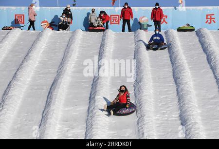 211230 -- BEIJING, Dec. 30, 2021 -- Visitors experience snow tubes at Yuanmingyuan Park in Beijing, capital of China, Dec. 30, 2021. The Old Summer Palace, or Yuanmingyuan, announced on Thursday that it will hold a ice and snow festival which opens around New Year s day in 2022 and lasts until February to welcome the Beijing 2022 Winter Olympic Games.  CHINA-BEIJING-YUANMINGYUAN PARK-WINTER FUN CN LuoxXiaoguang PUBLICATIONxNOTxINxCHN Stock Photo