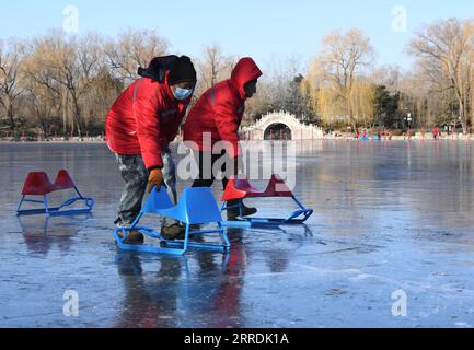 211230 -- BEIJING, Dec. 30, 2021 -- Staff members prepare sleds on a frozen lake at Yuanmingyuan Park in Beijing, capital of China, Dec. 30, 2021. The Old Summer Palace, or Yuanmingyuan, announced on Thursday that it will hold a ice and snow festival which opens around New Year s day in 2022 and lasts until February to welcome the Beijing 2022 Winter Olympic Games.  CHINA-BEIJING-YUANMINGYUAN PARK-WINTER FUN CN LuoxXiaoguang PUBLICATIONxNOTxINxCHN Stock Photo