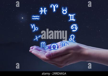 Astrology. Woman with zodiac wheel against starry night sky, closeup Stock Photo
