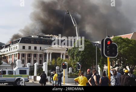 220103 -- CAPE TOWN, Jan. 3, 2022 -- People watch firefighters battling the fire that flares up again on the National Assembly building in Cape Town, South Africa, on Jan. 3, 2022. The fire service of South Africa s legislative capital Cape Town on Monday afternoon said that the parliament fire, which started on early Sunday, has flared up again. Photo by /Xinhua SOUTH AFRICA-CAPE TOWN-PARLIAMENT FIRE-FLARING UP XabisoxMkhabela PUBLICATIONxNOTxINxCHN Stock Photo