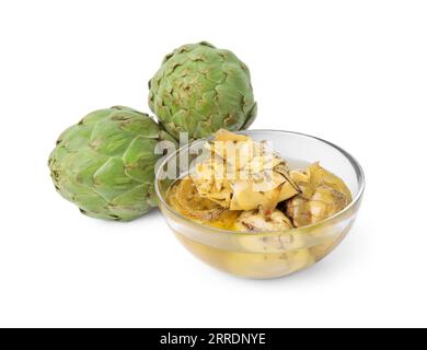 Bowl with delicious artichokes pickled in olive oil and fresh vegetables on white background Stock Photo