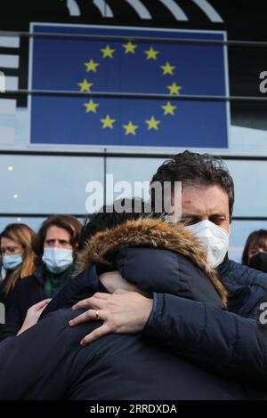 220111 -- BRUSSELS, Jan. 11, 2022 -- People hug each other after observing a moment of silence in memory of late European Parliament President David Sassoli, in front of the European Parliament in Brussels, Belgium, Jan. 11, 2022. European Parliament President David Sassoli died at age 65 at a hospital in Italy early Tuesday, his spokesperson has said. Sassoli, born on May 30, 1956, in Florence, Italy, had been hospitalized for more than two weeks due to a serious complication relating to immune system dysfunction. Sassoli was elected to the European Parliament in 2009. He became president of Stock Photo