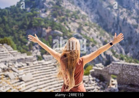 Woman tourist explores Stunning Ancient Theater of Termessos Ancient City turkiye, GO Everywhere Stock Photo