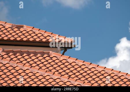 Overlapping rows of yellow ceramic roofing tiles covering residential building roof in southern Florida Stock Photo
