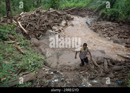 220301 -- WEST SUMATRA, March 1, 2022 -- A man walks in the mud after floods triggered by heavy rains and rising waters of the Batang Nango river after a 6.1-magnitude quake in Nagari Kajai village of Pasaman Barat district, West Sumatra, Indonesia, March 1, 2022. Photo by /Xinhua INDONESIA-WEST SUMATRA-FLOOD-AFTERMATH AndrixMardiansyah PUBLICATIONxNOTxINxCHN Stock Photo